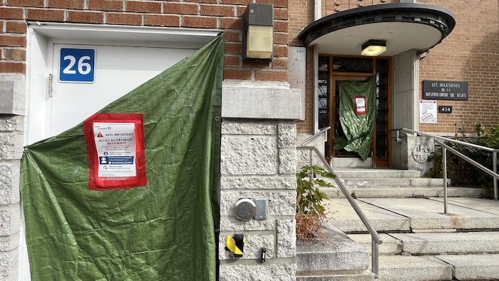 Une bâche verte est placée devant une porte.