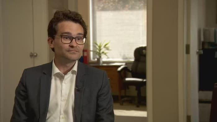 Un homme assis en entrevue.