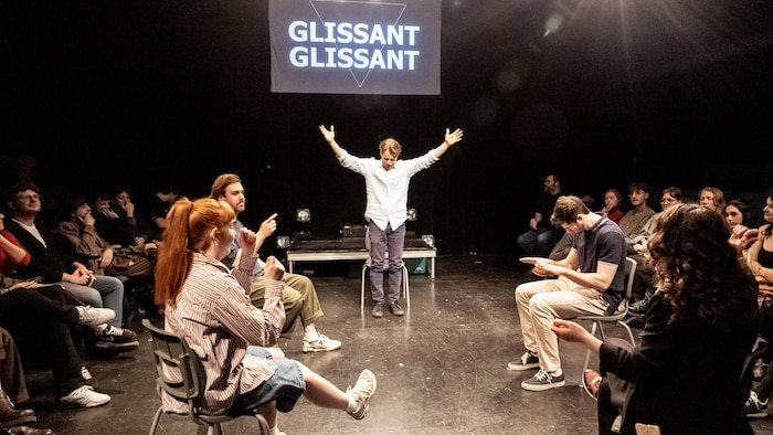 Les acteurs sont au centre de la scène, entourés de gens du public.

