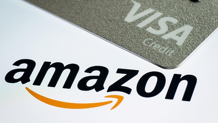 Une carte de crédit Visa apparaît au-dessus du logo Amazon sur l'écran d'accueil de l'application mobile.