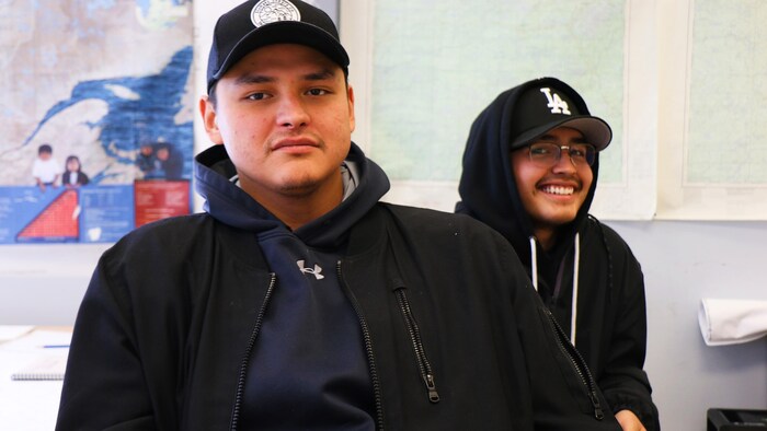 Deux jeunes hommes posent.