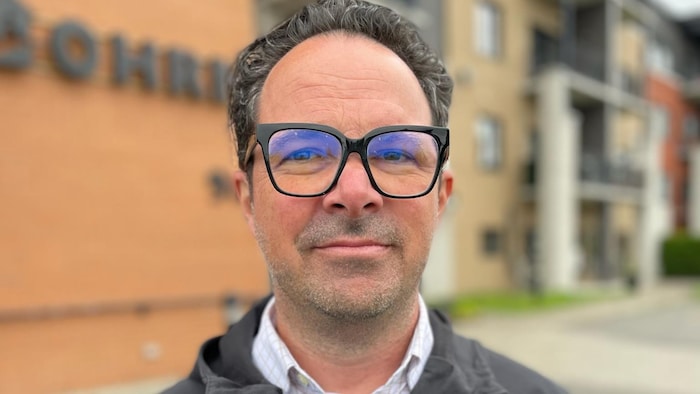 Portrait of Alain Boulianne in front of the offices of the Housing Office.