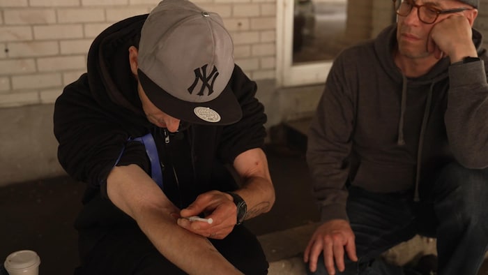 Un homme s'injecte de la drogue.