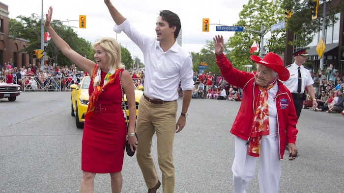 Bonnie Crombie, Justin Trudeau et Hazel McCallion marchent lors d'une parade et saluent la foule.