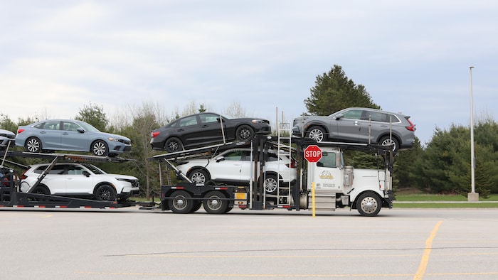 Un camion transporte des véhicules neufs.