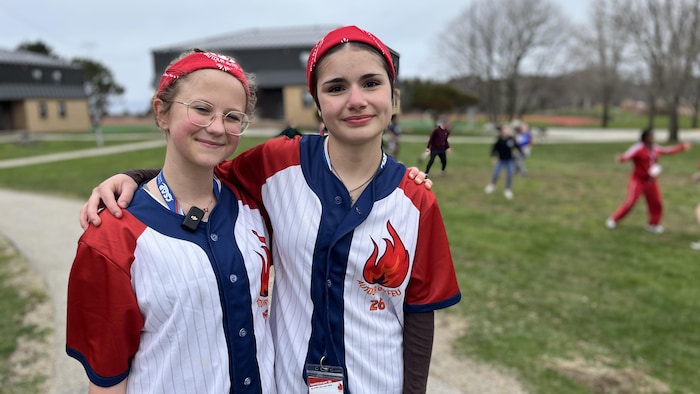 Deux jeunes élèves du secondaire qui sourient devant la caméra.