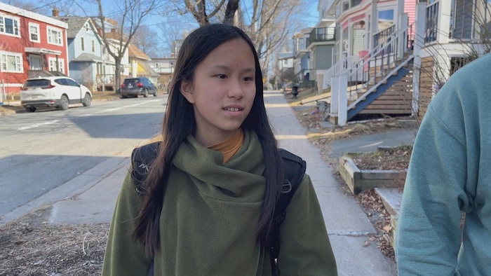 Une adolescente marche dans une rue d'Halifax.