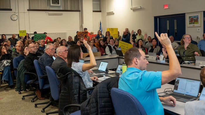 Des gens avec des mains levées devant une foule.