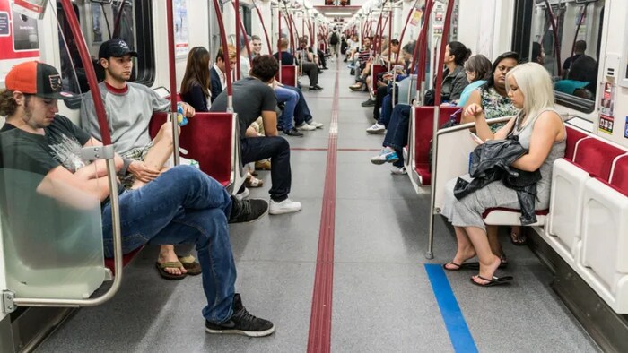 Des passagers dans un wagon de métro.