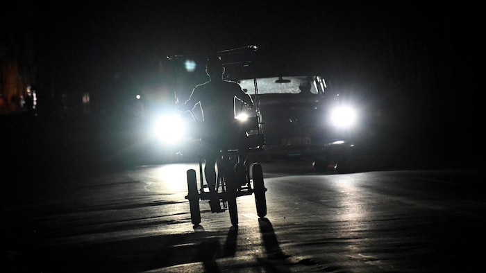 Un Cubain roule à vélo dans une rue de La Havane, le 15 mars 2025, lors d'une panne d'électricité nationale causée par une défaillance du réseau. 