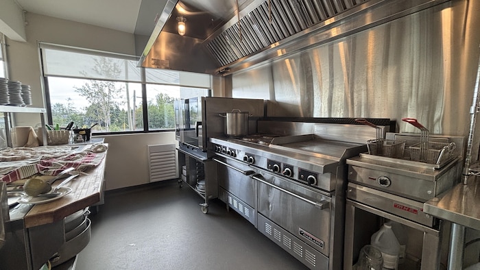 Un plan large montrant une cuisine professionnelle moderne et propre.