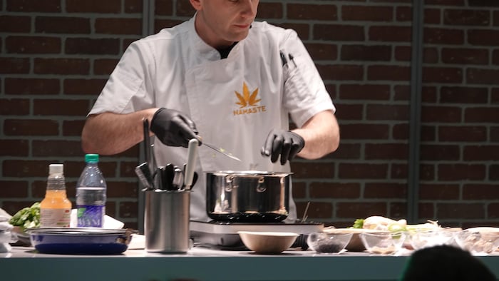Un homme cuisine avec du cannabis.