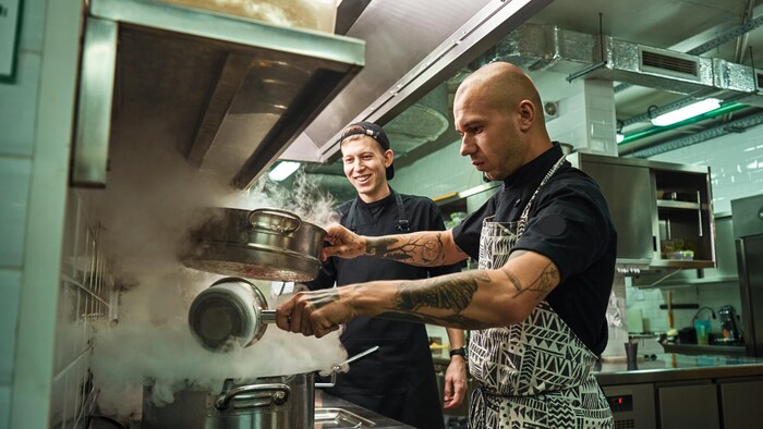 Un chef cuisinier et son assistant dans une cuisine de restaurant.