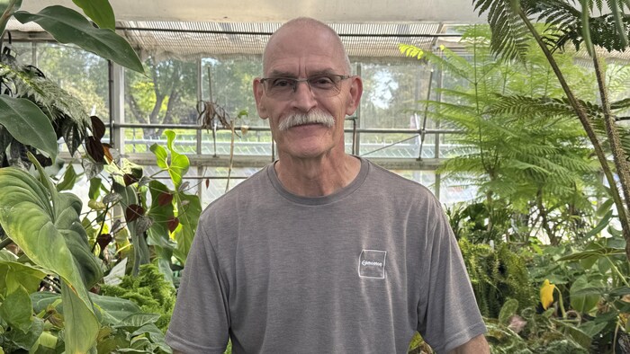 Gerard Amerongen de face dans une serre, avec des plantes.