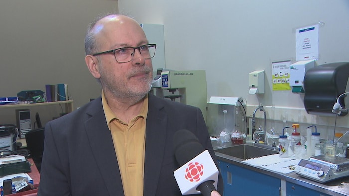 Un homme en entrevue dans un laboratoire.