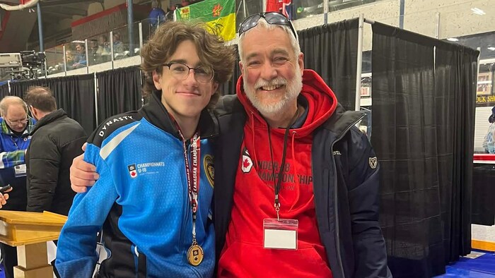 Nathan Beaudoin-Gendron, médaille d'or au cou, et Patrick Bédard posent pour la caméra en souriant.