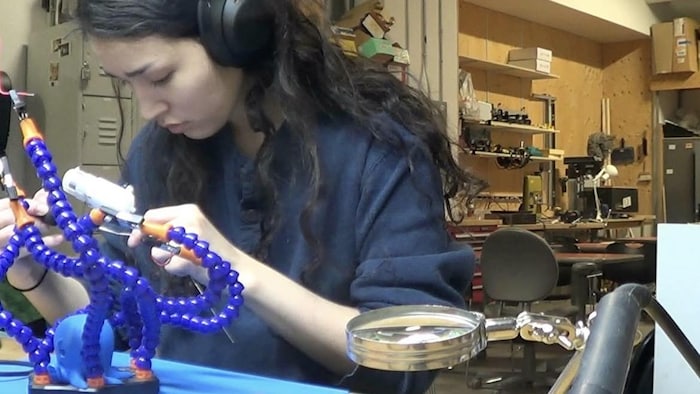Susanna Dioani travaille sur un objet électronique qui ressemble à une pieuvre.