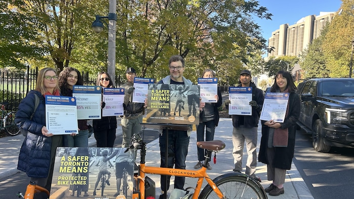 Michael Longfield et les bénévoles de Cycle Toronto brandissent des affiches concernant leur questionnaire.