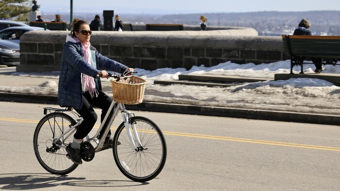 Une cycliste profite du beau temps sur les plaines d'Abraham.