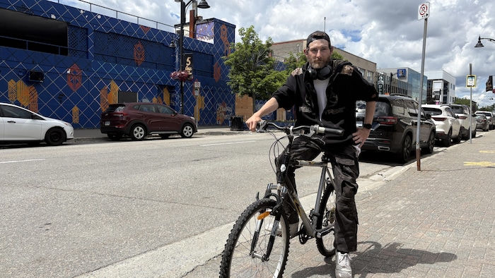 Un cycliste avec son vélo dans les rues de Sudbury.