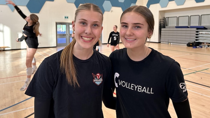 Deux joueuses de volleyball en portrait dans un gymnase. 
