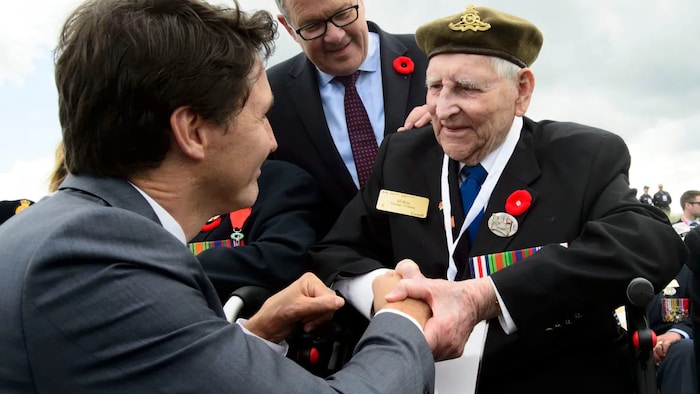 Veterans Affairs Minister Lawrence MacAulay looks on as Prime Minister Justin Trudeau shakes hands with Second World War veteran Al Roy as he visits Juno Beach. The interaction followed a 75th anniversary D-Day ceremony at Juno Beach in Courseulles-Sur-Mer, France, on June 6, 2019. (Sean Kilpatrick/The Canadian Press)