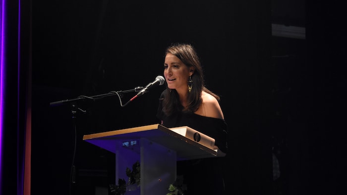 La femme sur sc&egrave;ne au micro durant les remerciements.