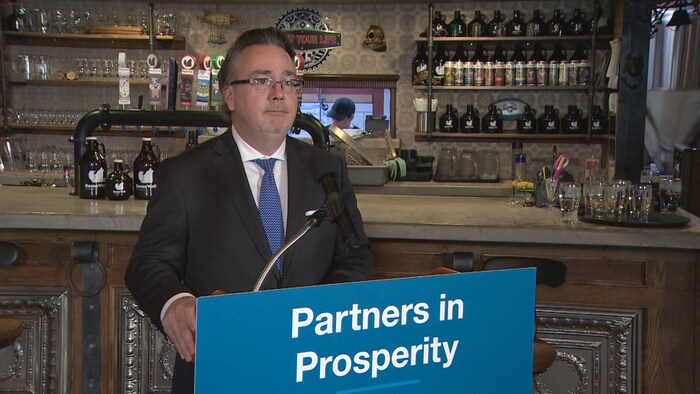Un homme à un lutrin, devant un bar, le 30 janvier 2023.