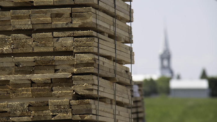 Une pile de bois devant une église.