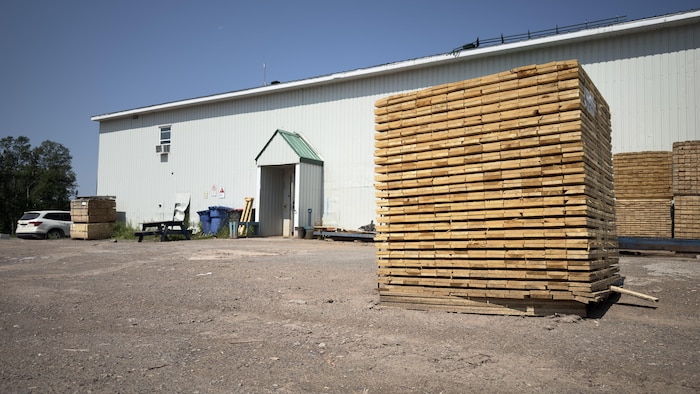 Une pile de bois devant un bâtiment.