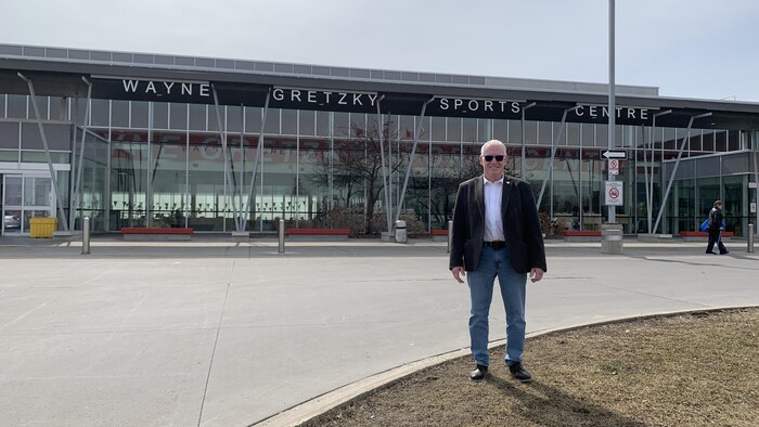 Le conseiller municipal Dan McCreary debout devant le complexe sportif Wayne Gretzky.