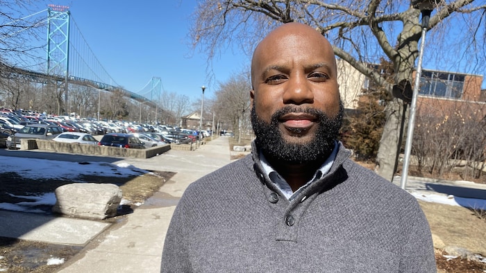 Un professeur debout devant un pont. 