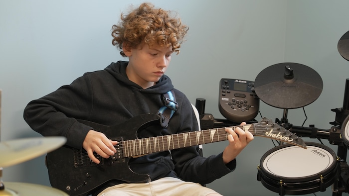 Danick Charron dans un local de musique.