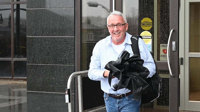 Une personne souriante sort du palais de justice de Moncton. 