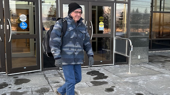 Un homme sort du palais de justice.