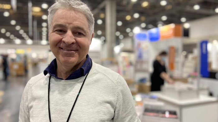 Daniel Gélinas photographié lors du Salon international du livre de Québec de 2022. Il sourit.
