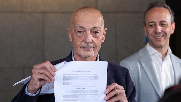Daniel Jolivet et son avocat, Me Nicholas St-Jacques, lors d'un point de presse sur les marches du palais de justice de Montréal.