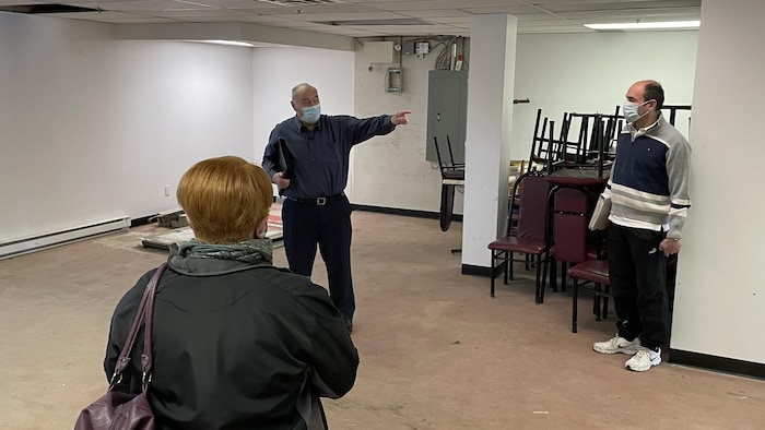 Daniel Lafleur, directeur de scrutin dans la circonscription fédérale de Hull-Aylmer, s'adresse à deux personnes dans un local.