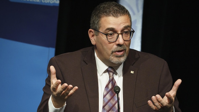 Quebec's vaccination chief, Daniel Barry, sits during a news conference.