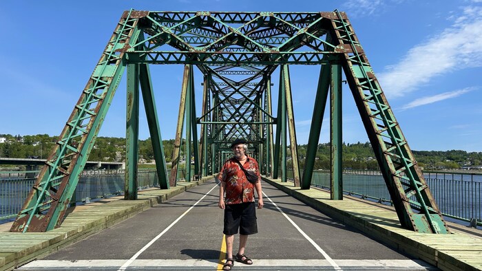 Une homme devant un pont. 