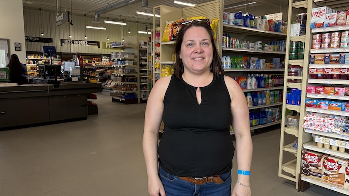 La propriétaire de la pharmacie et de l'épicerie JL Joncas à Lourdes-de-Blanc-Sablon pose devant des étagères de son épicerie.