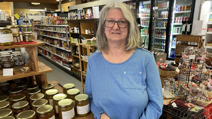 Danielle Samson est accoté sur un table dans son commerce. 