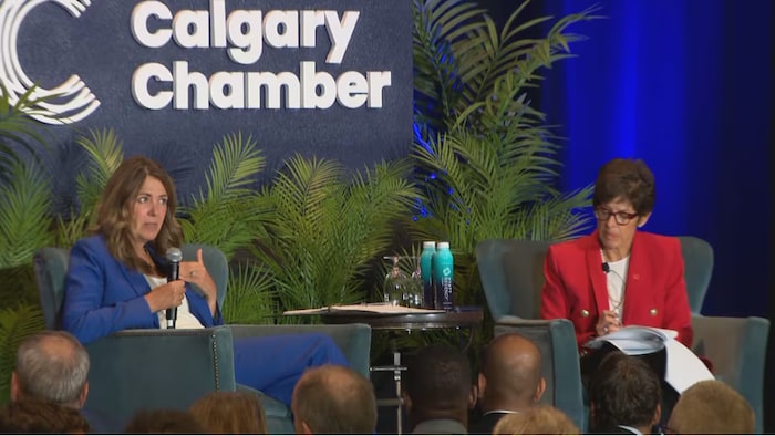 Danielle Smith est assise à côté de la présidente de la Chambre de commerce de Calgary, Deborah Yedlin.
