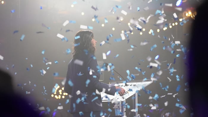 Danielle Smith est sur scène et souriante, de dos avec des confettis qui lui tombent dessus, le 29 mai 2023, après avoir gagné les élections provinciales, en Alberta.