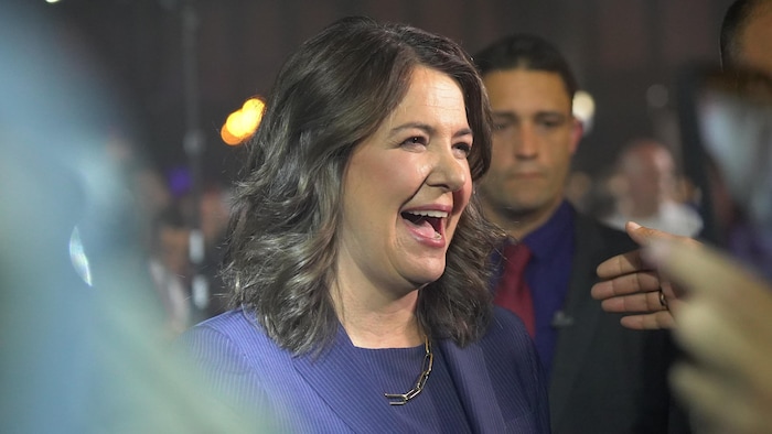 Danielle Smith souriante est entourée de la foule sur scène, le 29 mai 2023, après avoir gagné les élections provinciales, en Alberta.