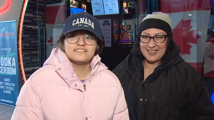Une jeune fille et une femme joyeuses sourient à la sortie du bar Real Canadian Icehouse d'Edmonton.