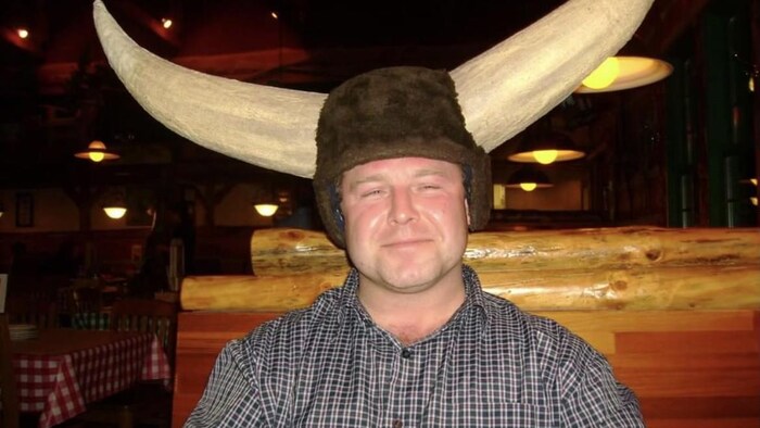 Danny Robinson coiffé d'un chapeau avec de grandes cornes sourit dans un restaurant.