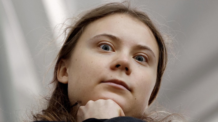 Greta Thunberg regarde la caméra avec des grands yeux très sérieux.