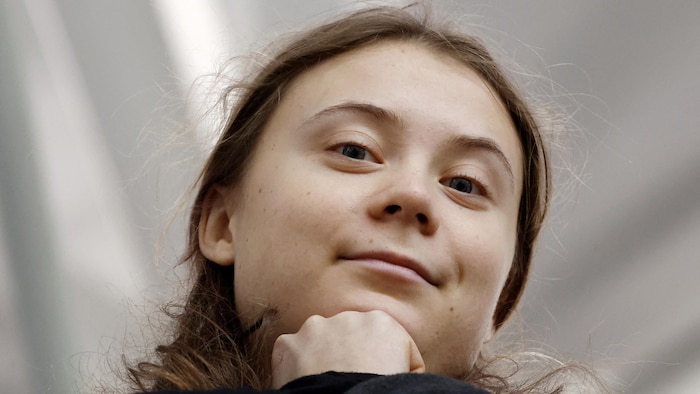 Greta Thunberg regarde la caméra en souriant.