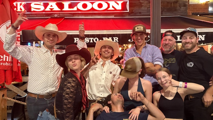 De jeunes danseurs country posent ensemble, à l’extérieur, devant le restaurant Jack Saloon, sur la rue des Forges de Trois-Rivières.